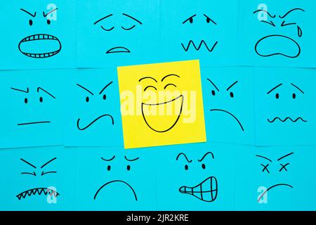 Faces with different emotions drawn on sticky notes. Concept about positive attitude, customer satisfaction, happiness. Stock Photo