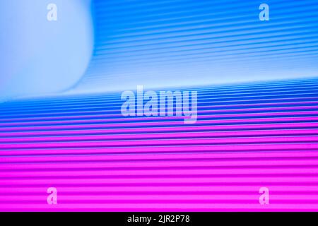 Neon hues over corrugated magenta and blue background. Futuristic abstract backdrop Stock Photo