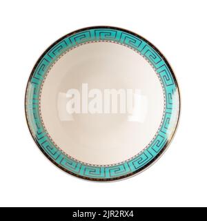 White bowl with turquoise border isolated on a white background. Porcelain deep dish decorated with a golden meander ornament on a blue border. Stock Photo