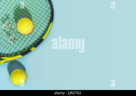 Tennis composition with yellow tennis balls and racket on a blue background of hard tennis court with copy space. Sport flat lay. The concept of outdo Stock Photo