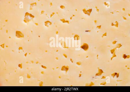 A piece of Russian cheese with holes close-up Stock Photo