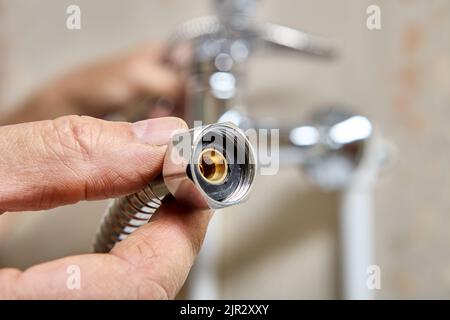 Flexible hose for shower head, plumber replaced rubber gasket seal to fix leak. Stock Photo