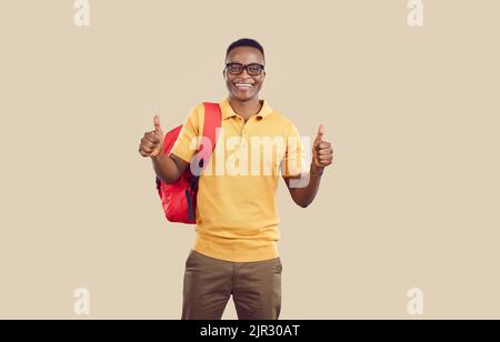 Happy successful African American university student showing thumbs up and smiling Stock Photo