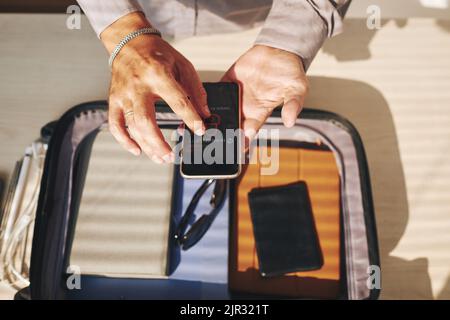 Close-up of businessman unlocked his smartphone. He's going on a trip Stock Photo