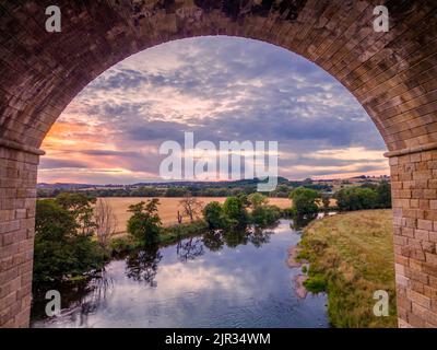 UK Weather: Beautiful eerial view of the sunset over the Yorkshire countryside and the River Wharfe viewed through an arch of Arthington Viaduct. Stock Photo