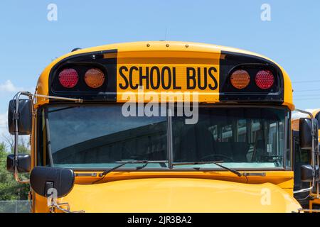 School Bus staging area waiting for students. School buses are an effective transportation method in rural districts. Stock Photo