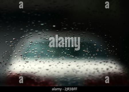 A rainy view of water droplets on the rear windscreen of an old car Stock Photo