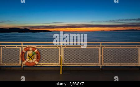 Ring life boy on big boat.Obligatory ship equipment.Personal flotation device. Orange lifesaver on the deck of a ship Stock Photo