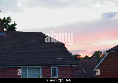 Sunset sky and English house on foreground. Stock Photo