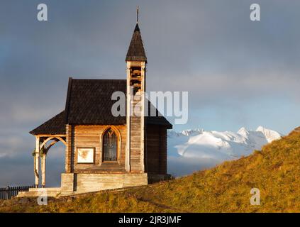 Morning view of small wooden church or chapel on the mountain top Col di Lana and Mount Marmolada, Alps Dolomites mountains, Italy Stock Photo