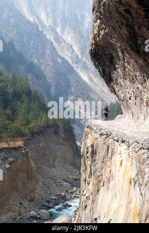 man on the way, rock road in round Annapurna circuit trekking trail, Nepal Stock Photo