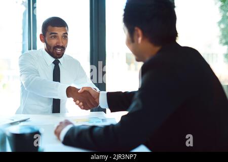 Glad to have you on our team. a two businessmen shaking hands in the workplace. Stock Photo