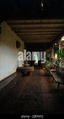 stone wheel among pots and plants, in an old house in mexico latin america Stock Photo