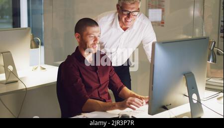 Howre you getting on. two businessmen working together on a computer in their office. Stock Photo