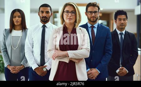 Committed to the mission of succeeding big. Portrait of a diverse group of businesspeople standing in an office. Stock Photo