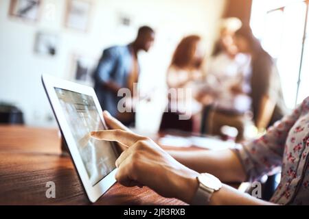 The internet can aid a businesses in achieving the perfect image. an unrecognizable woman using a digital tablet at the office. Stock Photo