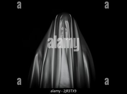 Scary white ghost sheet on black background for Halloween Festival concept. Stock Photo