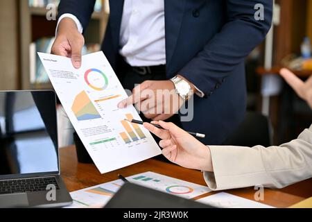 A professional businessman or male boss showing the financial report to his team in the financial meeting. cropped and closeup image Stock Photo