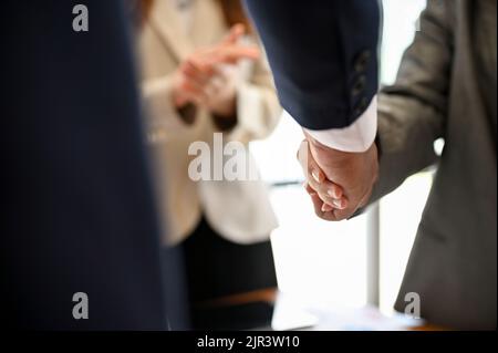 Businessman in formal suit shaking hands with his business partner in the meeting. cropped image Stock Photo