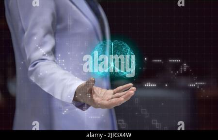 Woman doctor holding hand with holographic brain, stoke prevention concept and rehabilitation of stroke program Stock Photo