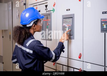 Electrical young asian woman engineer examining maintenance cabinet system electric and using tablet in control room at industrial factory, technician Stock Photo