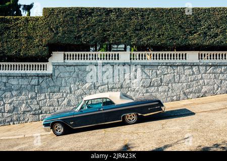 1962 Ford Galaxie 500XL Sunliner in blue, parked on street/sidewalk near mansion Stock Photo