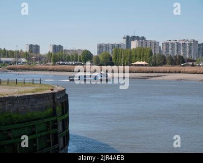 Antwerp, Belgium, April 17, 2022, Waterbus the Blue Amigo sails on the river Scheldt to the left bank Stock Photo