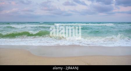 velvet season seascape. waves rushing on the beach. cloudy sky before the evening storm Stock Photo
