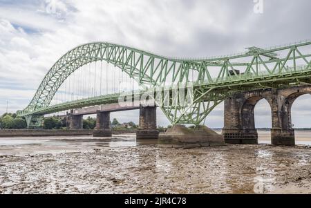 Silver Jubilee Bridge and Runcorn Railway Bridge pictured from the banks of the River Mersey in Cheshire.