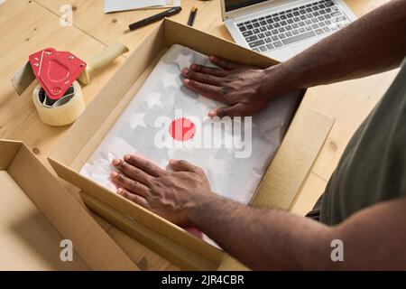 High angle view of worker packing the order in box at table before shipping Stock Photo