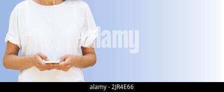 Woman in the forty's with smartphone against gradient white blue background with large copy space Stock Photo