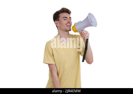 Young caucasian man shouting through megaphone, isolated. Stock Photo