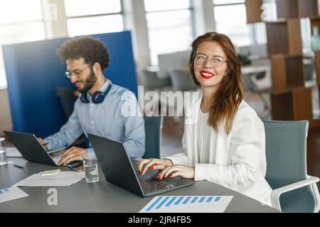 Two coworkers working together analyzing the charts in office Stock Photo