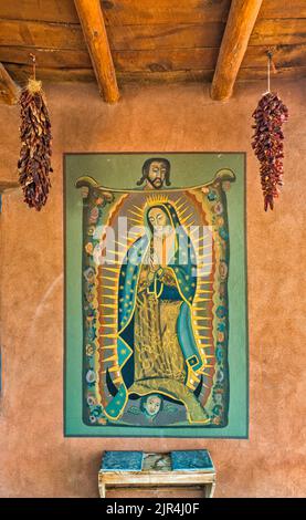 Virgin of Guadalupe mural, built in 1975 in historic Joe M Granito block at First Street in Los Cerrillos, The Turquoise Trail, New Mexico, USA Stock Photo