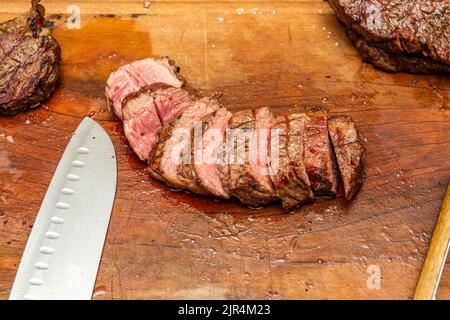 medium rare tri-tip steak sliced on a cutting board Stock Photo