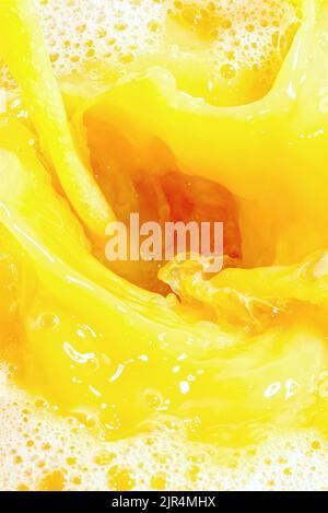 Closeup of splashing orange juice, top view. Splash of fresh sweet orange, mango, fruit juice. Stock Photo