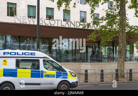 Police van driving past New Scotland Yard Metropolitan Police headquarters on Victoria Embankment, Westminster, London, England, UK Stock Photo