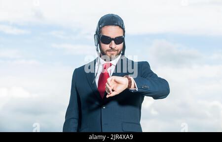 businessman in suit and pilot hat checking time Stock Photo
