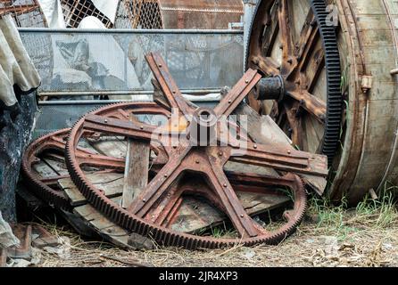Details of Old large cog wheels for Wooden barrels for the tanning of cattle leather was left to deteriorate over time. Selective focus. Stock Photo