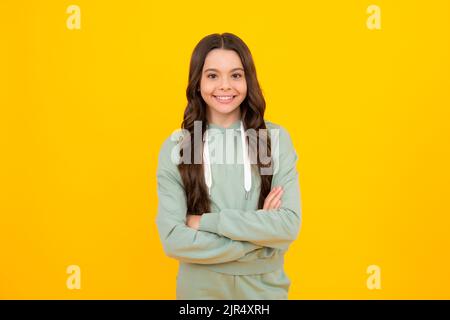 Portrait of teenager girl crossed arms isolated on yellow color background. Children lifestyle childhood concept. Stock Photo