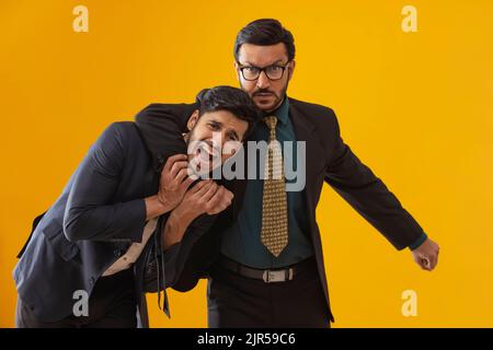 Corporate employees in formal business suit with one wrapping his hand around other's neck. Stock Photo