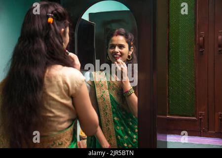 Beautiful woman doing make up in front of mirror Stock Photo
