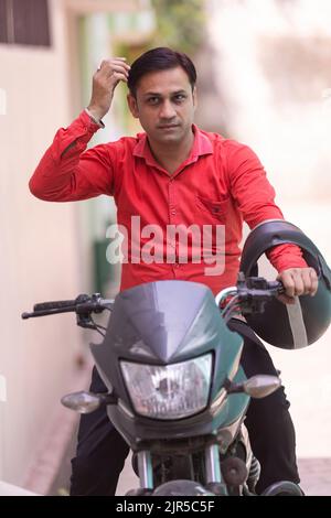 Portrait of young man sitting on Motorcycle Stock Photo