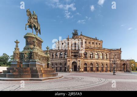 The Semper Opera building and the statue of King John of Saxony under the blue sky in Dresden Stock Photo