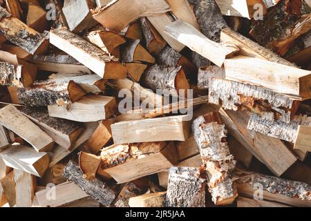 Birch firewood chopped with an axe. Messy wood pile, close-up. Stock Photo