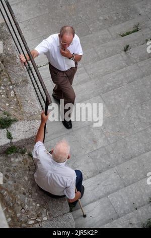 street photography conversation of two old men in a village of western Sicily, Italy Stock Photo