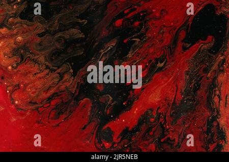 Acrylic texture made in fluid pour technique. Background in red and black colors. Stock Photo