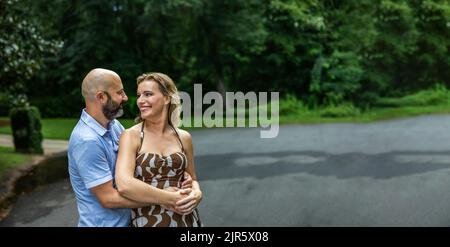 A caucasian couple in their forties outside looking at one another with copy space Stock Photo