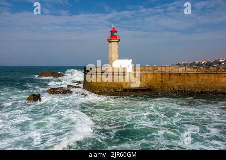 Waves crashing against the base of Farol das Felgueiras lighthouse at Foz do Douro near Porto in northern Portugal. Stock Photo