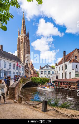 The Church of Our Lady viewed across the Dijver bridge over the canal in Bruges, Belgium Stock Photo